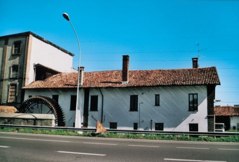 Mulino Fiocchi, sulla Via Emilia, tuttora attivo. Si  noti la ruota idraulica, in ferro, che utilizzava  lacqua della roggia Spazzola.