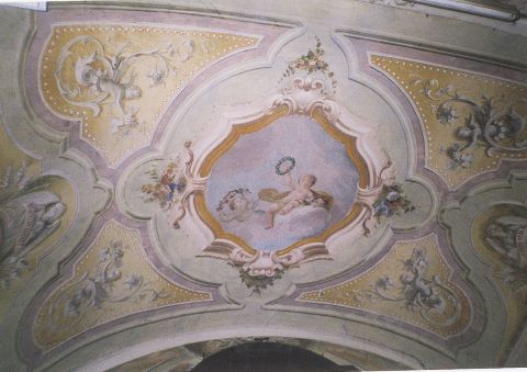 Particolare dell'oratorio di San Lorenzo: decorazione del soffitto dell'abside: puttino circondato da rami floreali.
