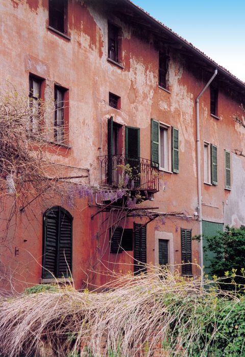 Veduta della  cascina, a ridosso  della chiesa, con  glicine.