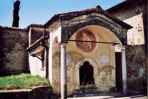 Cappelletta  Ossario, in stile  classicheggiante,  con pronao  sostenuto da due  colonne di granito.  Sulla parete sotto  il portico, tondo  del Rivetta:  Madonna con  Bambino.