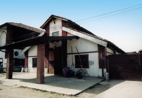 Prospetto della cascina con tetto a capanna e portico.