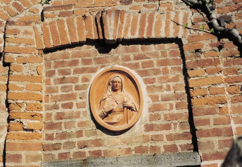 Particolare della loggia: tondo con Madonna in terracotta.