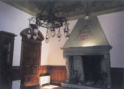 Sala da  pranzo con  lampadario in ferro  battuto; camino in  pietra con lo stemma della famiglia  riprodotto sulla  cappa; porta e  zoccolo in noce.