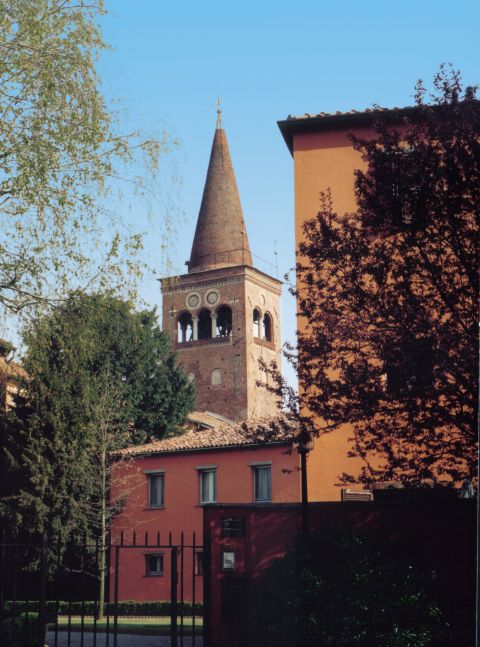 Cancello daccesso al monastero; sullo sfondo,  il campanile, alleggerito da bifore e trifore.