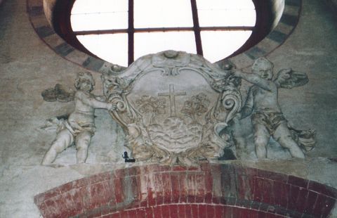 Particolari all'interno della chiesa di San Pietro e Paolo: stemma degli Olivetani sorretto da due angeli, raffigura un monte  sormontato da una croce affiancata da due ulivi.