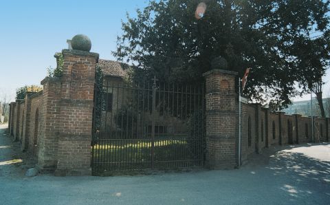 Cancello in ferro e muro di cinta in mattoni cotti del giardino della chiesa di S. Maria.